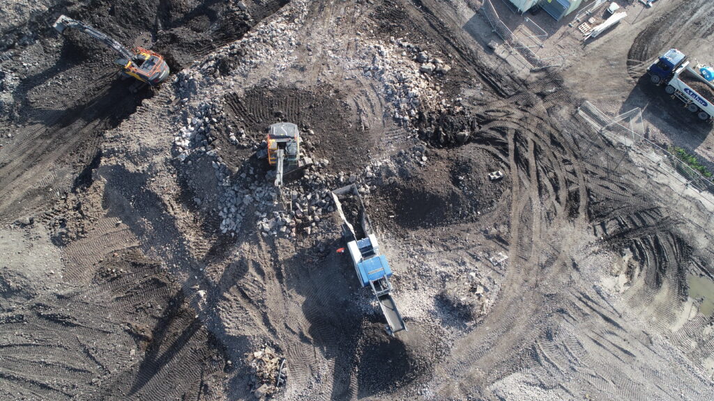 Birds eye view of BSH excavators removing debris from contaminated land after the site has undergone complete demolition.