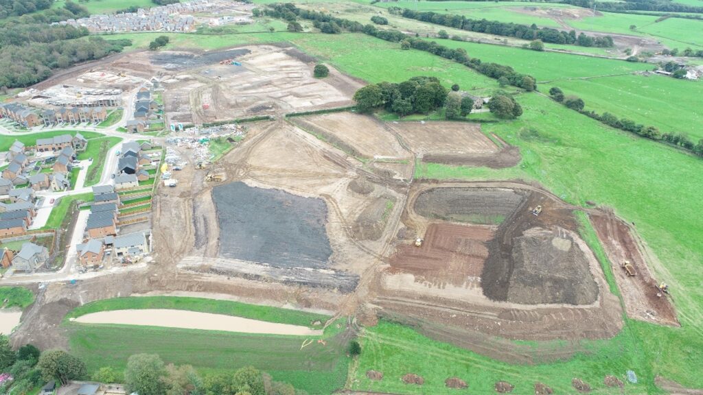 A complete greenfield redevelopment site that has undergone earthworks by BSH, situated adjacent to an existing housing estate in the UK.