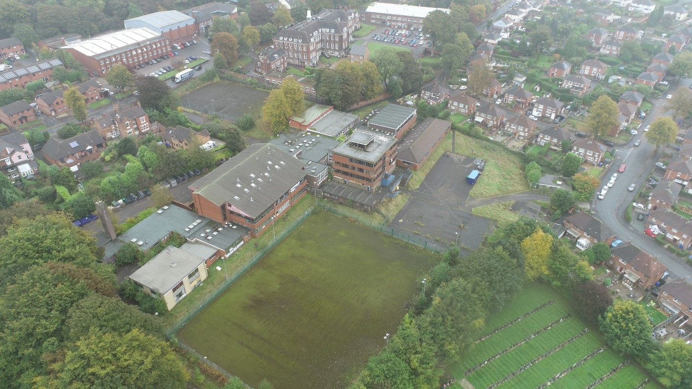 The Lioncourt Homes site before site clearance and demolition, showing an old school building surrounded by housing. Significant slope issues can be seen, highlighting the need for demolition, remediation, and bulk earthworks.